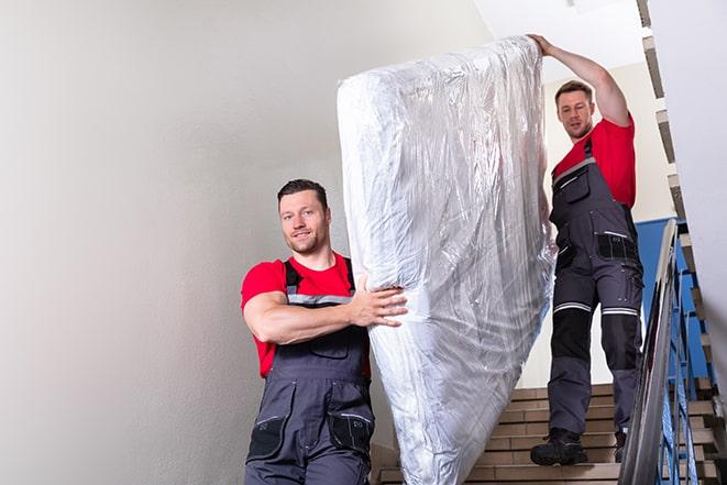 heavy-duty box spring being removed from a bedroom in Beach City